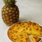 Pineapple Stuffing for Holidays: The Sweetest Side on the Table 4 Homemade pineapple stuffing in a white dish with a fresh whole pineapple